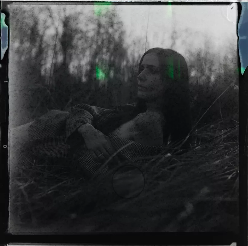 Analoges Portrait einer Frau, die im hohen Gras liegt